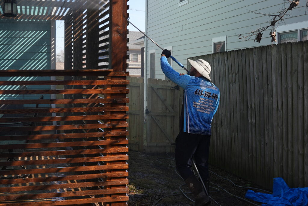 Wash Nash TN technician cleaning a wood privacy fence in Nashville